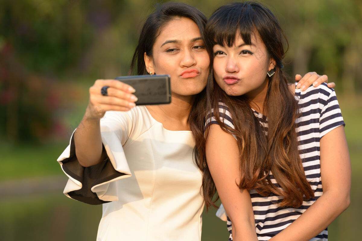 亚洲人两位亚洲年轻女性在公园户外放松的写真东南在一起亲吻