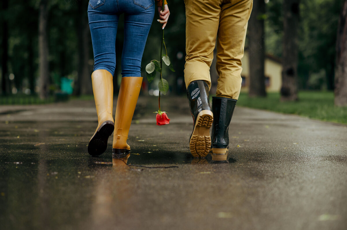 保护一对恋人在公园散步 夏日多雨戴曼和女人一起悠闲 浪漫的约会在小路上 潮湿的天气在巷子里年轻男性男朋友