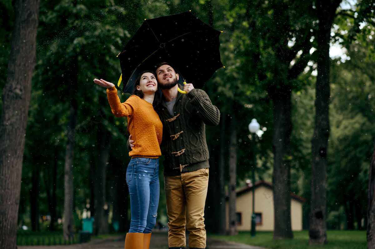 森林幸福的爱情夫妻享受夏日的雨天戴曼雨中的女人站在雨伞下 漫步小径上的浪漫约会 小巷里的潮湿天气拥抱公园在一起