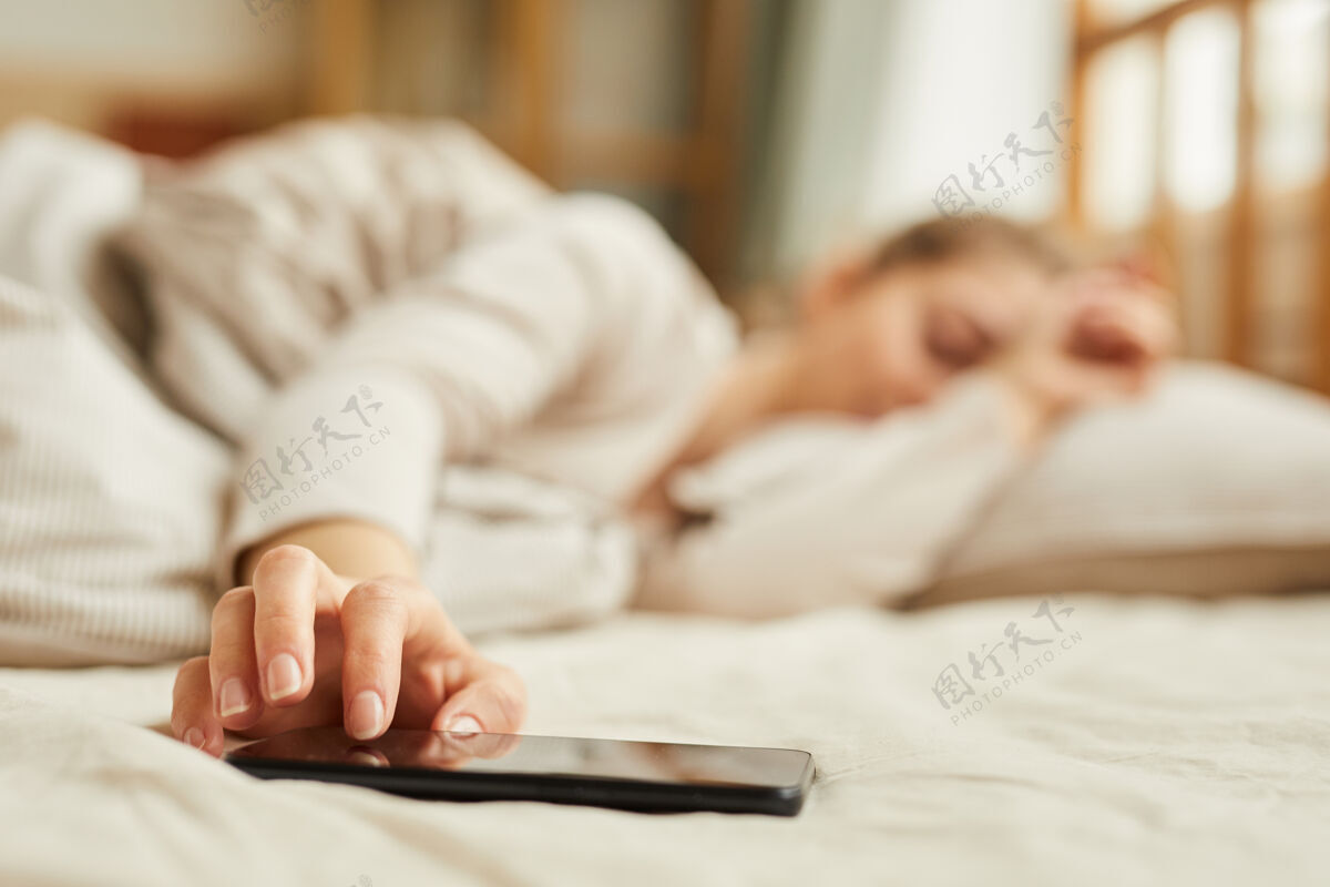 抱着女人睡觉时关掉手机闹钟的特写镜头枕头早晨通讯