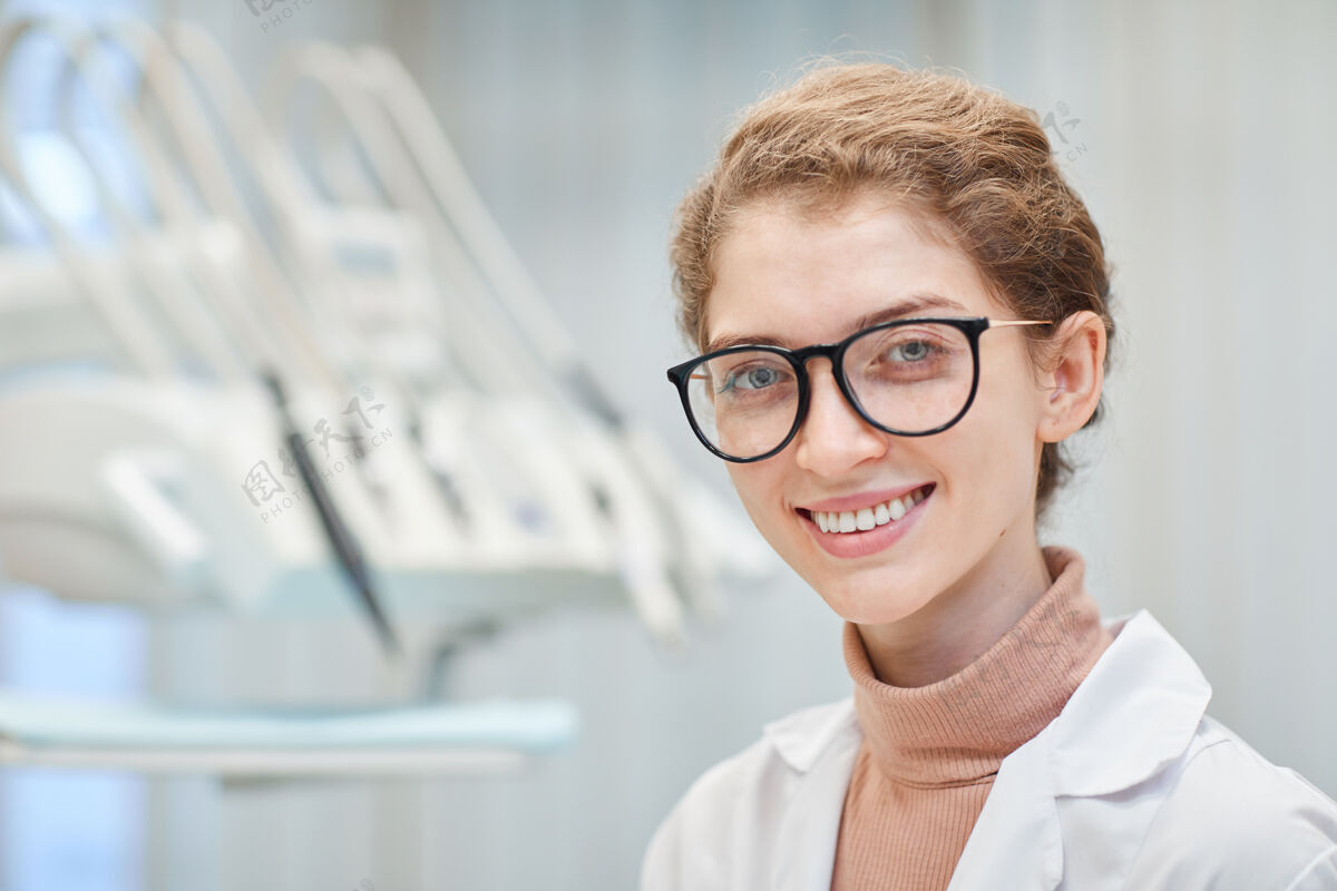 人脸戴眼镜的年轻女医生站在医院前面微笑的特写镜头美丽商业人士职业