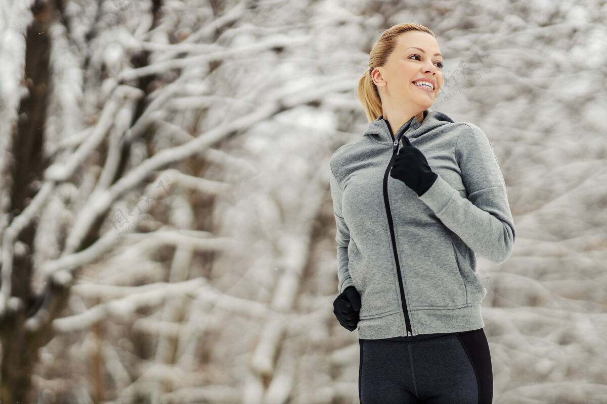 运动冬雪中在树林里跑步的女运动员白天冬天健身 健康生活 自然雪慢跑健康