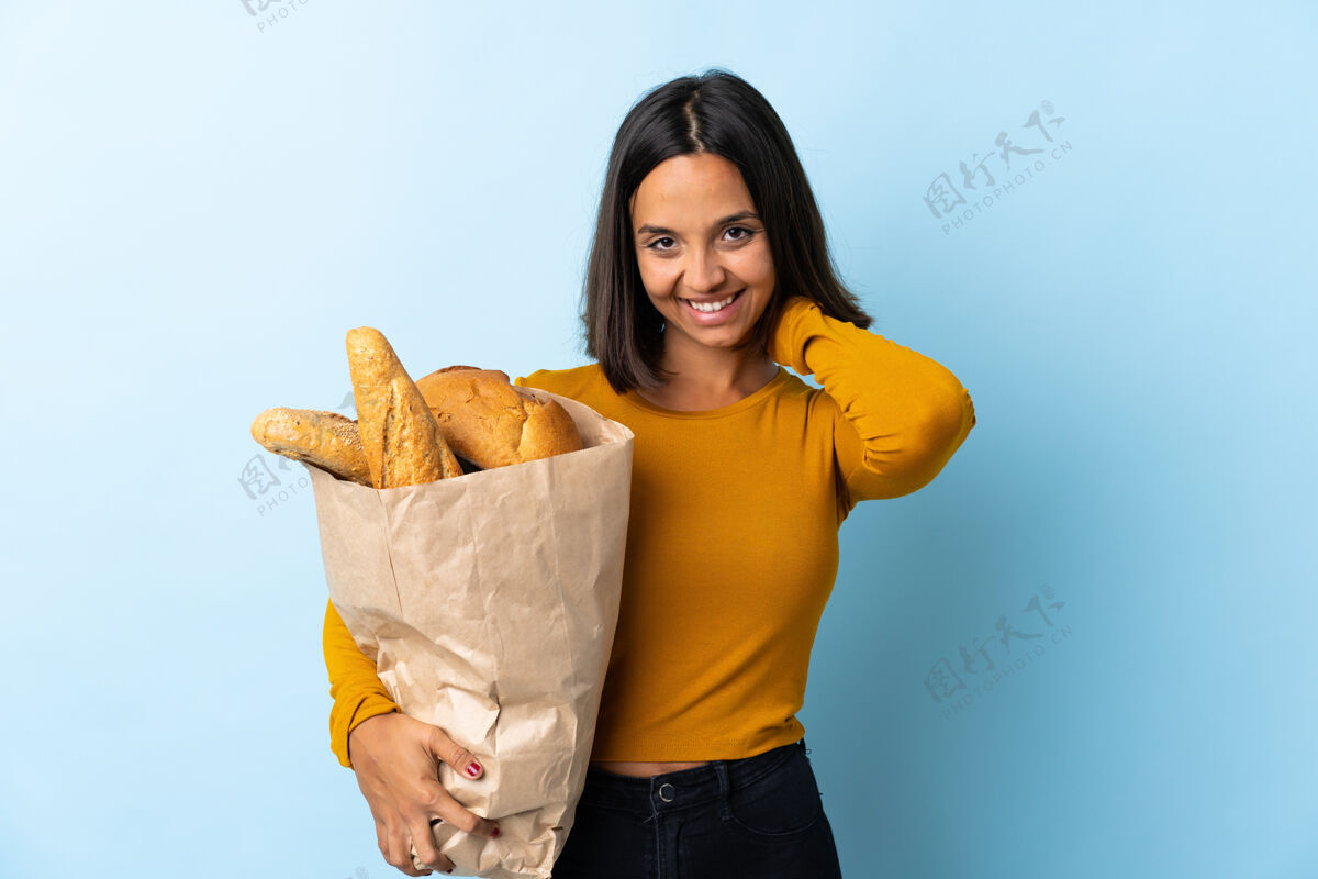 脸一个年轻的拉丁女人在买面包 在蓝色的椅子上笑厨房女人表情