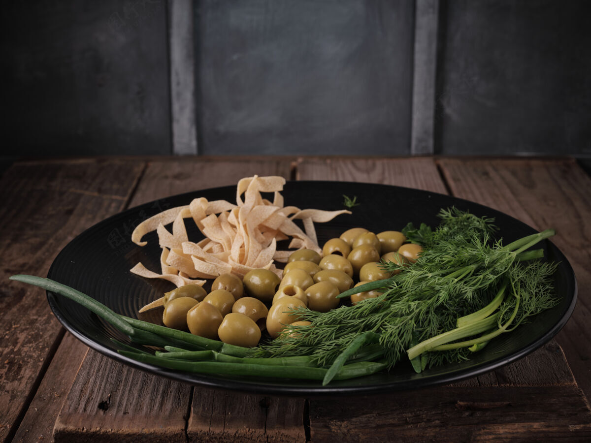 蔬菜意大利面 橄榄 葱和莳萝放在盘子里菜肴烹饪餐桌
