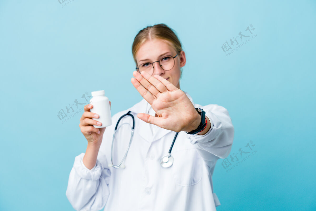 安全年轻的俄罗斯女医生拿着蓝色的药瓶做着否认的手势药片禁止俄罗斯