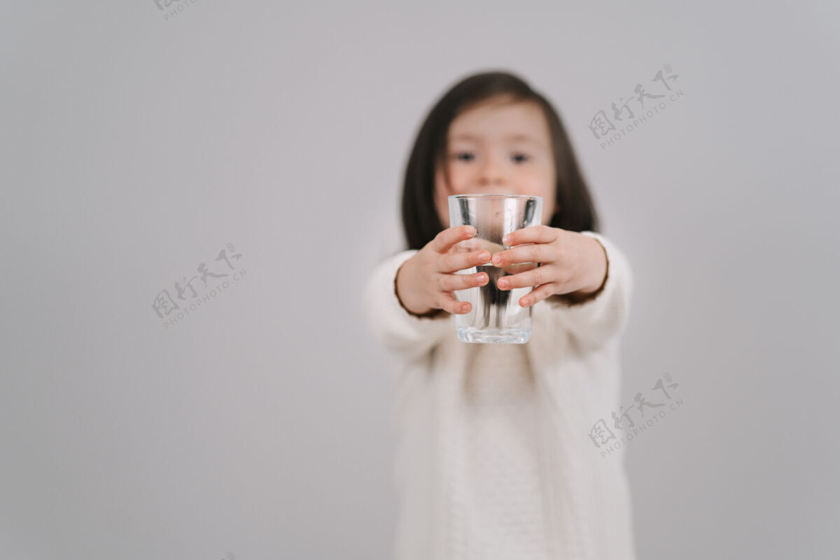 玻璃孩子手里拿着一杯咖啡水水女孩想喝水无辜快乐休闲