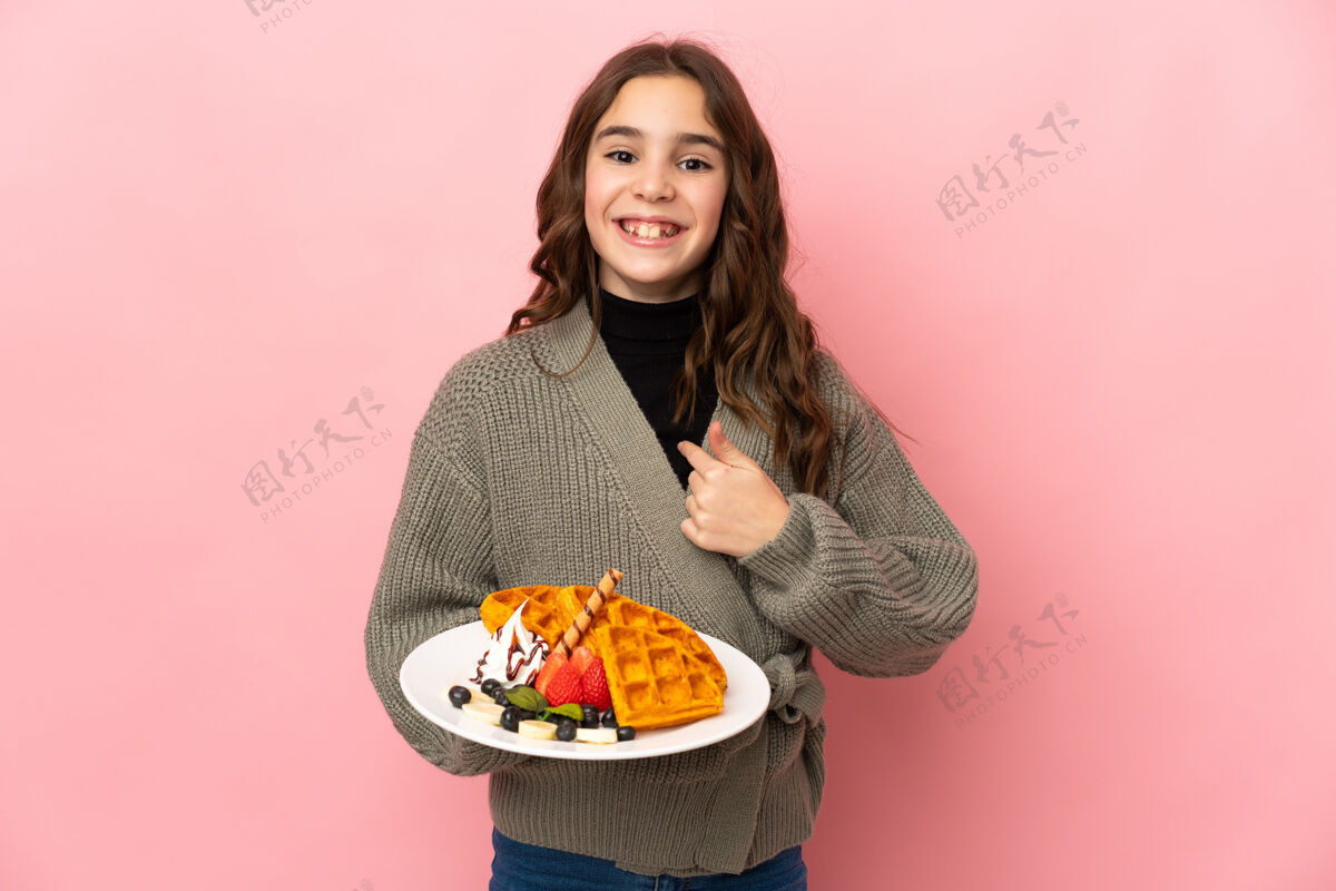 女性一个拿着华夫饼的小女孩 脸上带着惊讶的表情运气奶油早餐