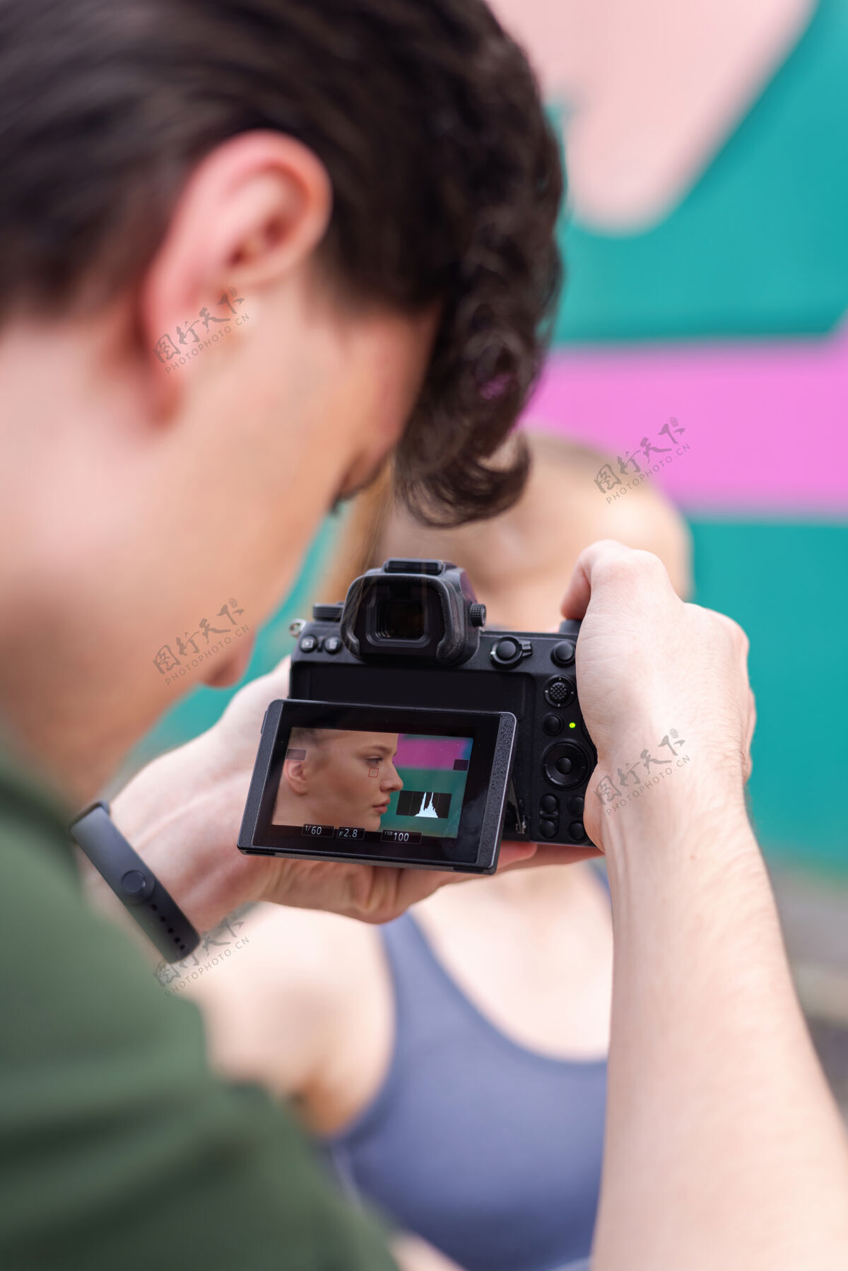 运动员摄影师拍摄的一个年轻的金发女子在户外训练穿着运动服 五彩背景健康年轻手
