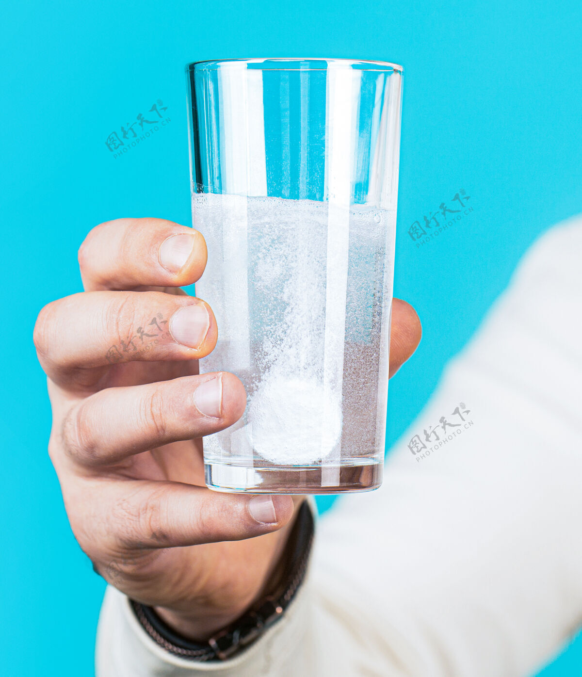 护理白色药丸和一杯水在男人手中健康理念泡沫药丸疾病