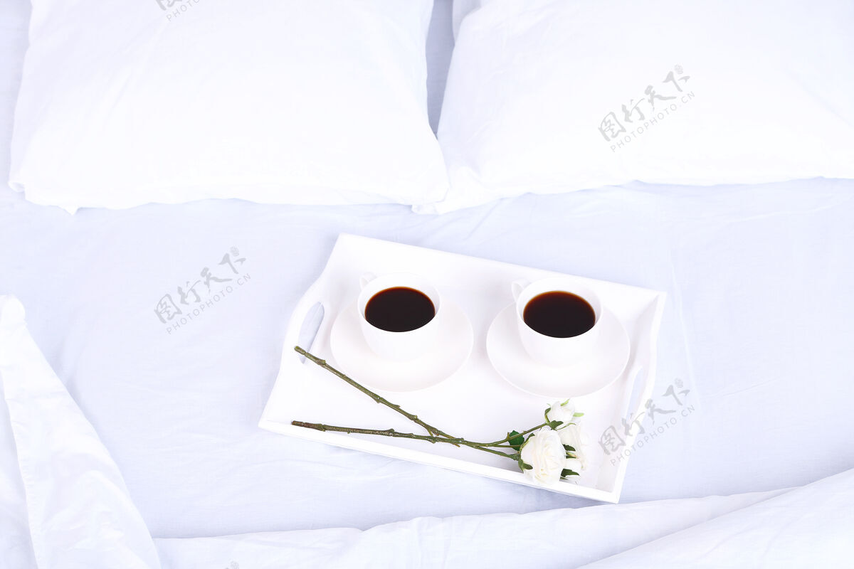 卧室在舒适柔软的枕头床上喝杯咖啡毯子公寓杯子