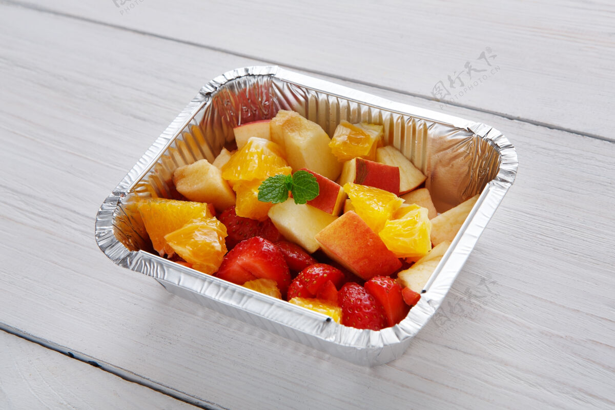 切片健康的甜点甜味水果沙拉特写在锡箔纸送货箱里水果品种浆果