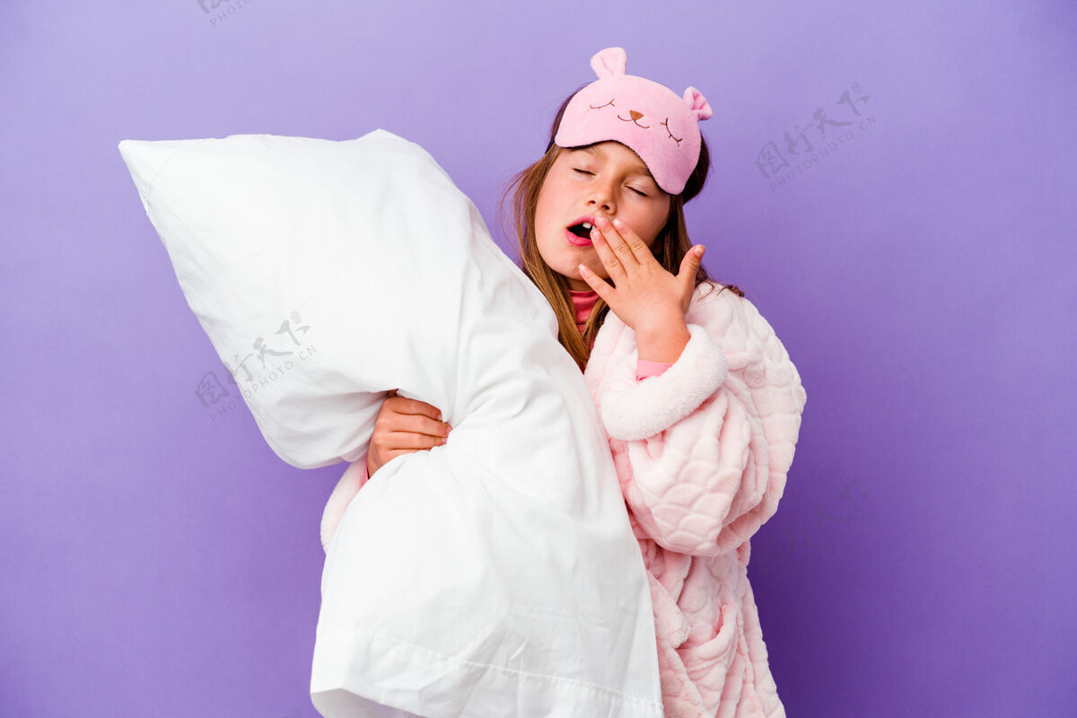 人小女孩抱着一个枕头快乐地孤立在紫色上早晨孩子气孩子