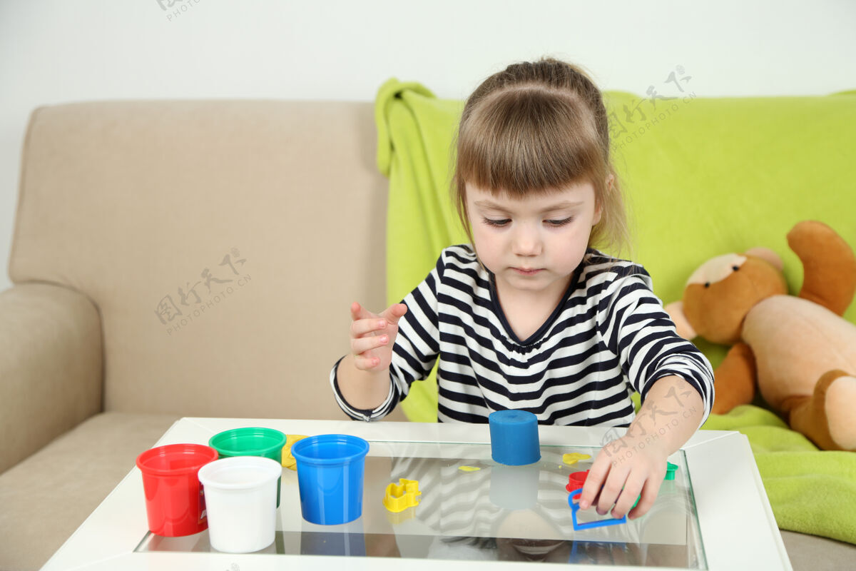 漂亮小女孩在玩五颜六色的粘土工艺手软