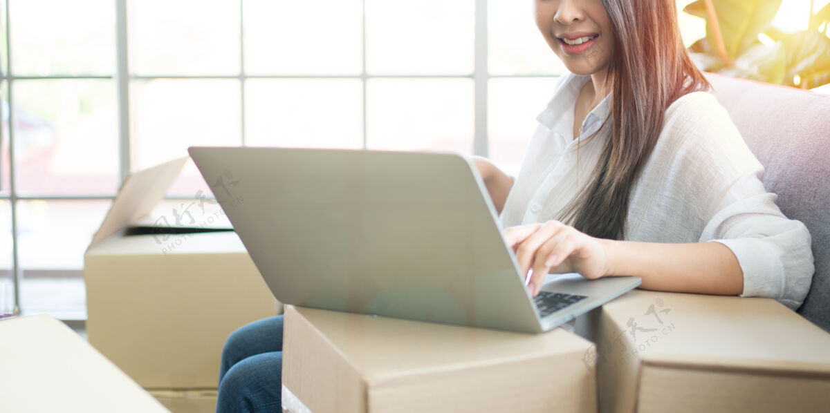 房子快乐的年轻亚洲女企业家 在家庭办公室的笔记本电脑中查看网上商店的订单后 微笑着等待销售成功包装人电子商务