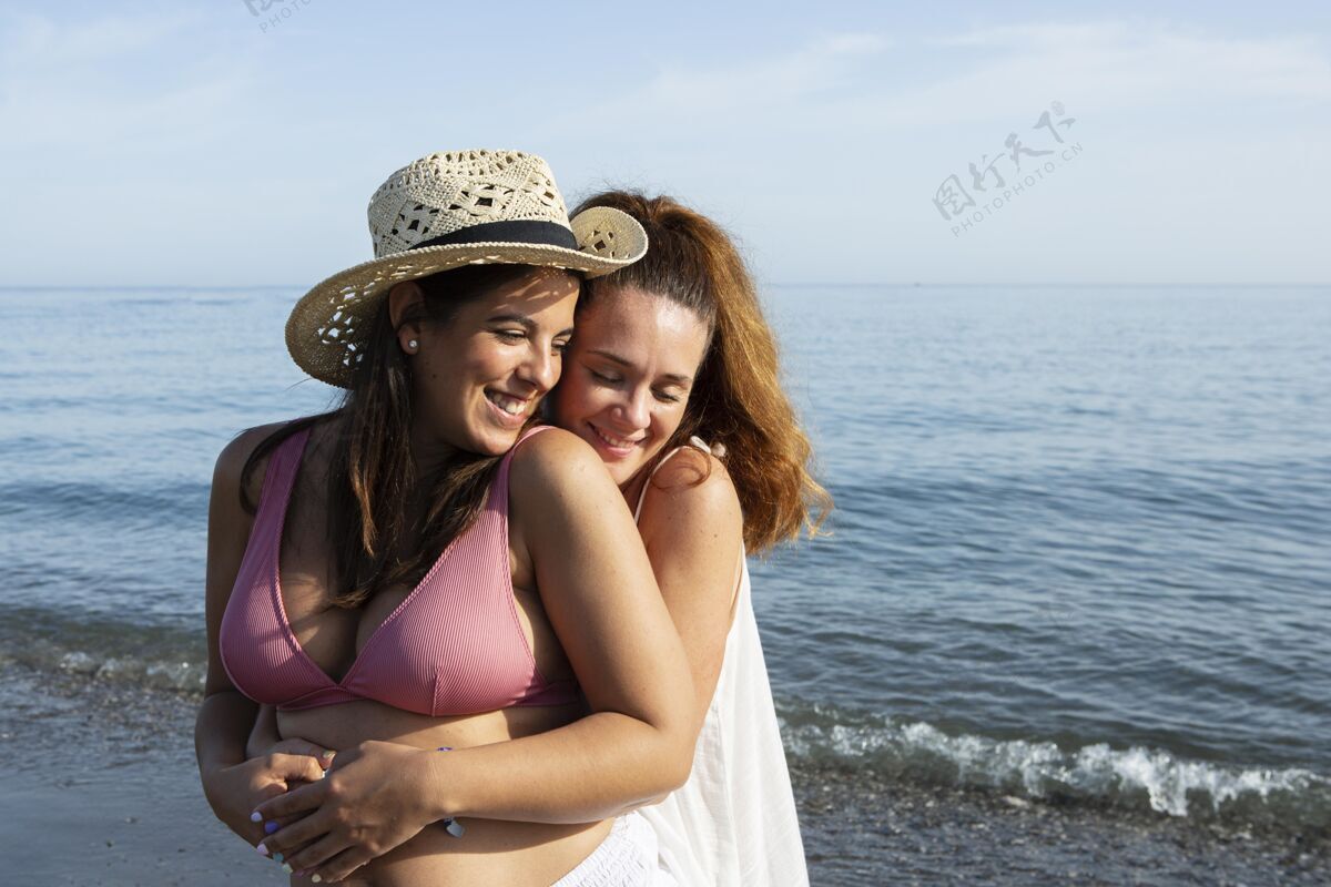海边在海边拥抱的中镜头女人放松乐趣假日