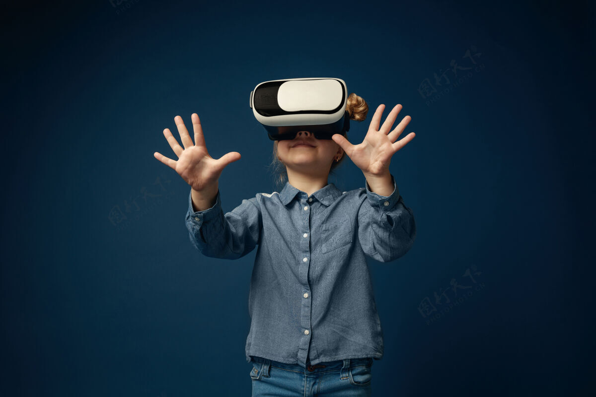 现实想知道的感觉小女孩或孩子在牛仔裤和衬衫与虚拟现实耳机眼镜隔离在蓝色工作室背景概念的尖端技术 视频游戏 创新小视觉科学