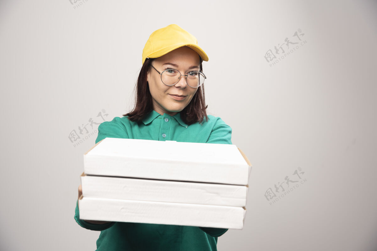 香气女送货员在一张白色高质量的照片上给披萨纸板女性纸箱帽子