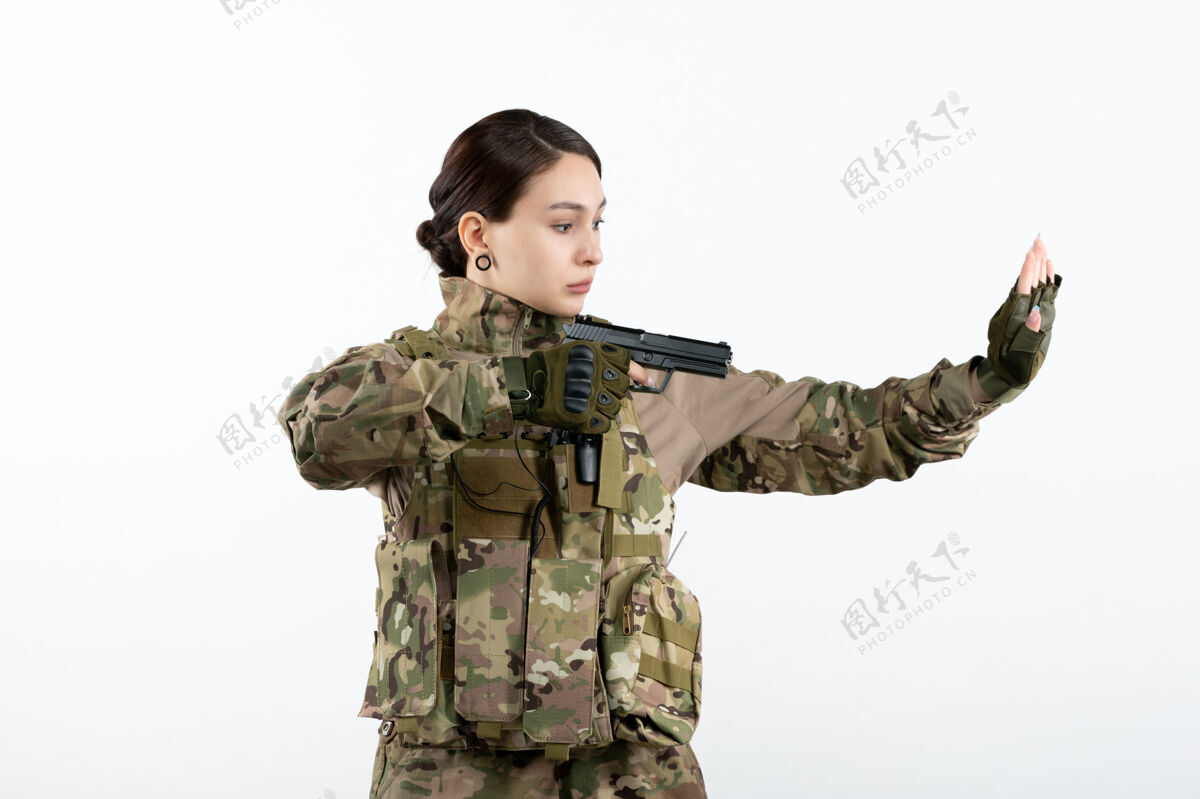军前视图：白墙上带枪的伪装女兵步枪武器视图