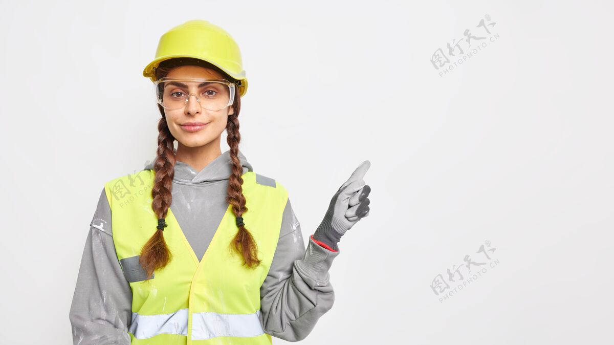 站立专业女工工程师 身着工作服 戴防护头盔 透明眼镜和手套 在复印区展示建筑工程理念技术制造眼镜