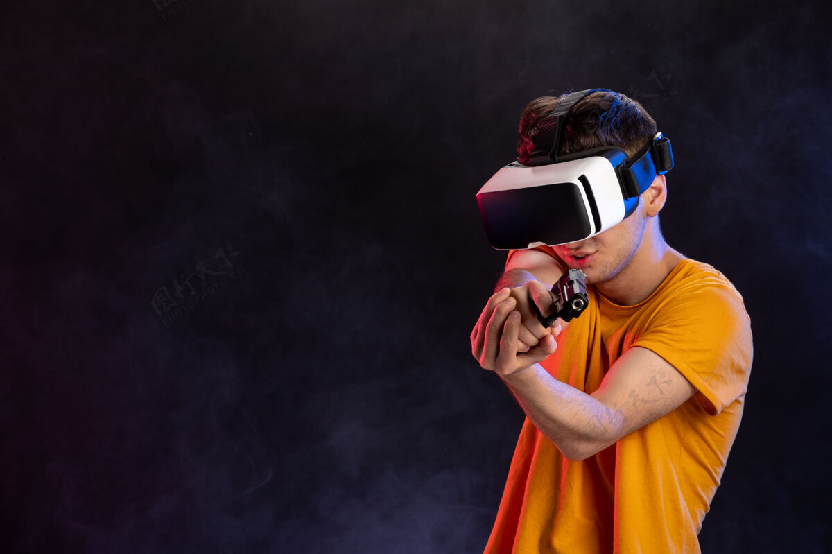 枪年轻男子玩虚拟现实与枪上一个黑暗的游戏技术视频玩磁盘骑师面具