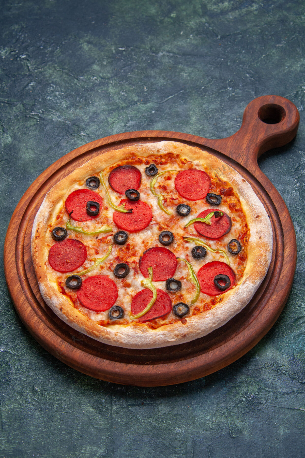 西红柿美味的比萨饼放在深蓝色的木砧板上 在垂直方向上有自由空间皮晚餐正餐