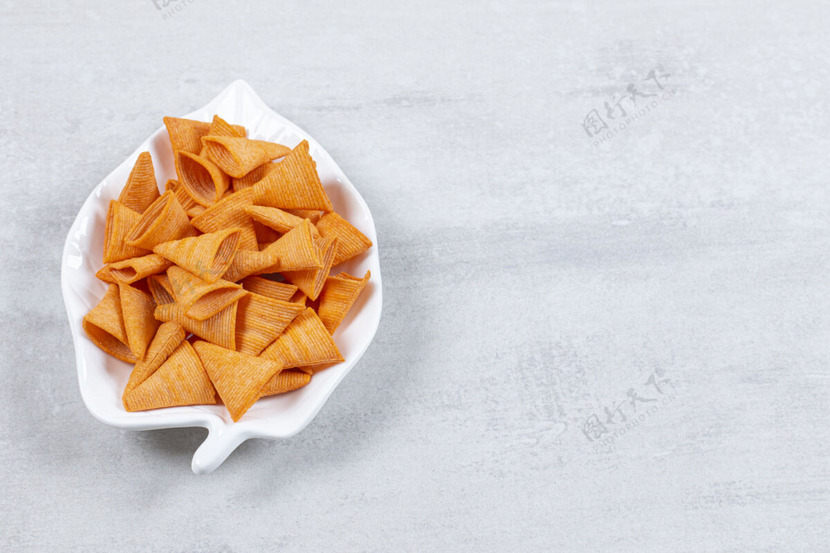 三角美味的三角片放在叶子形状的盘子上美味咸薯条
