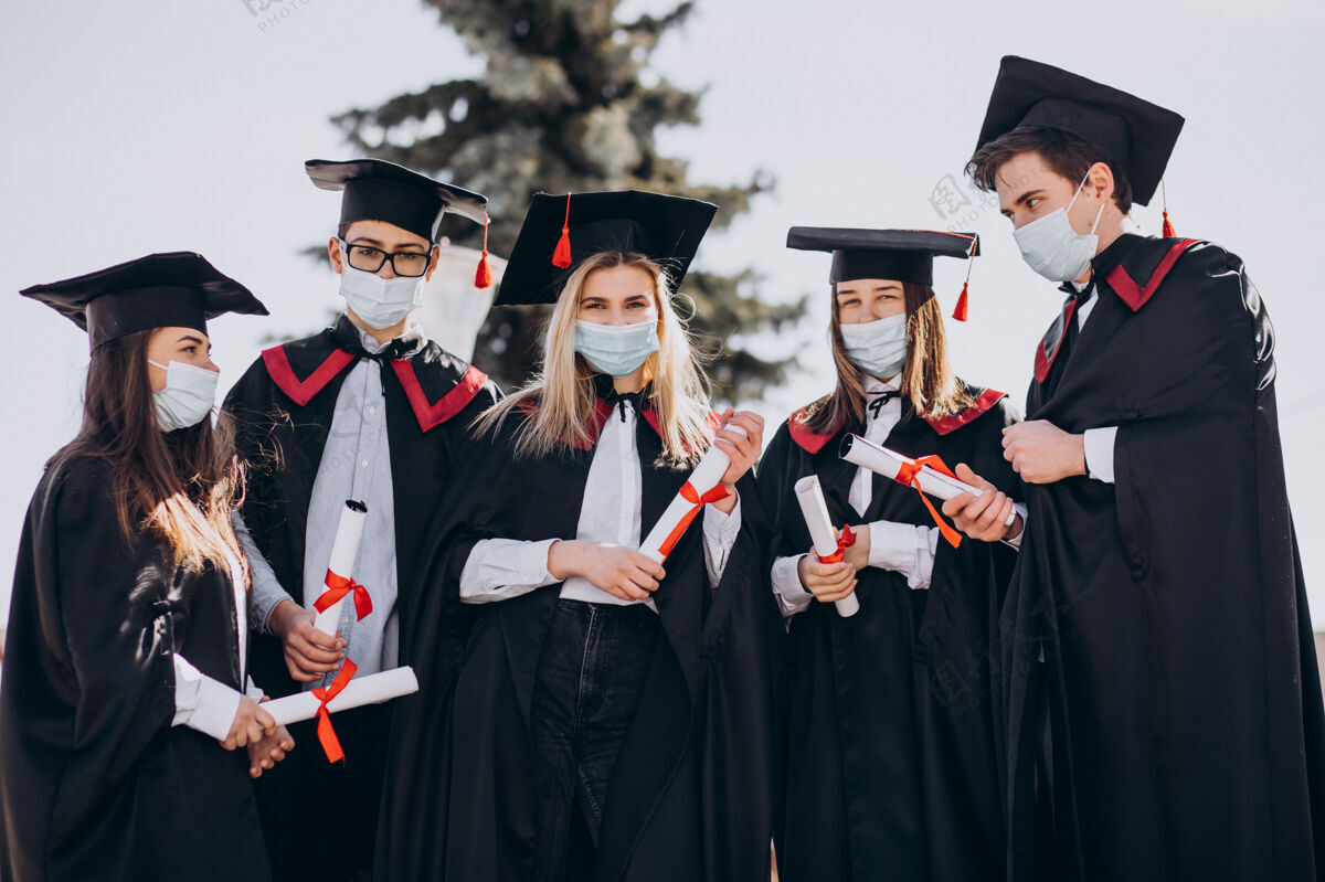 证书一群戴着口罩一起庆祝毕业的学生毕业帽成功披风