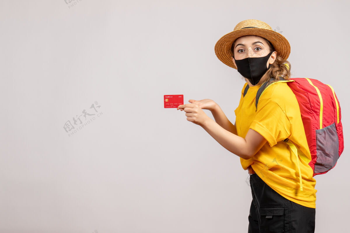 人正面图戴着黑色面具的年轻女子手持卡片面具付款持有