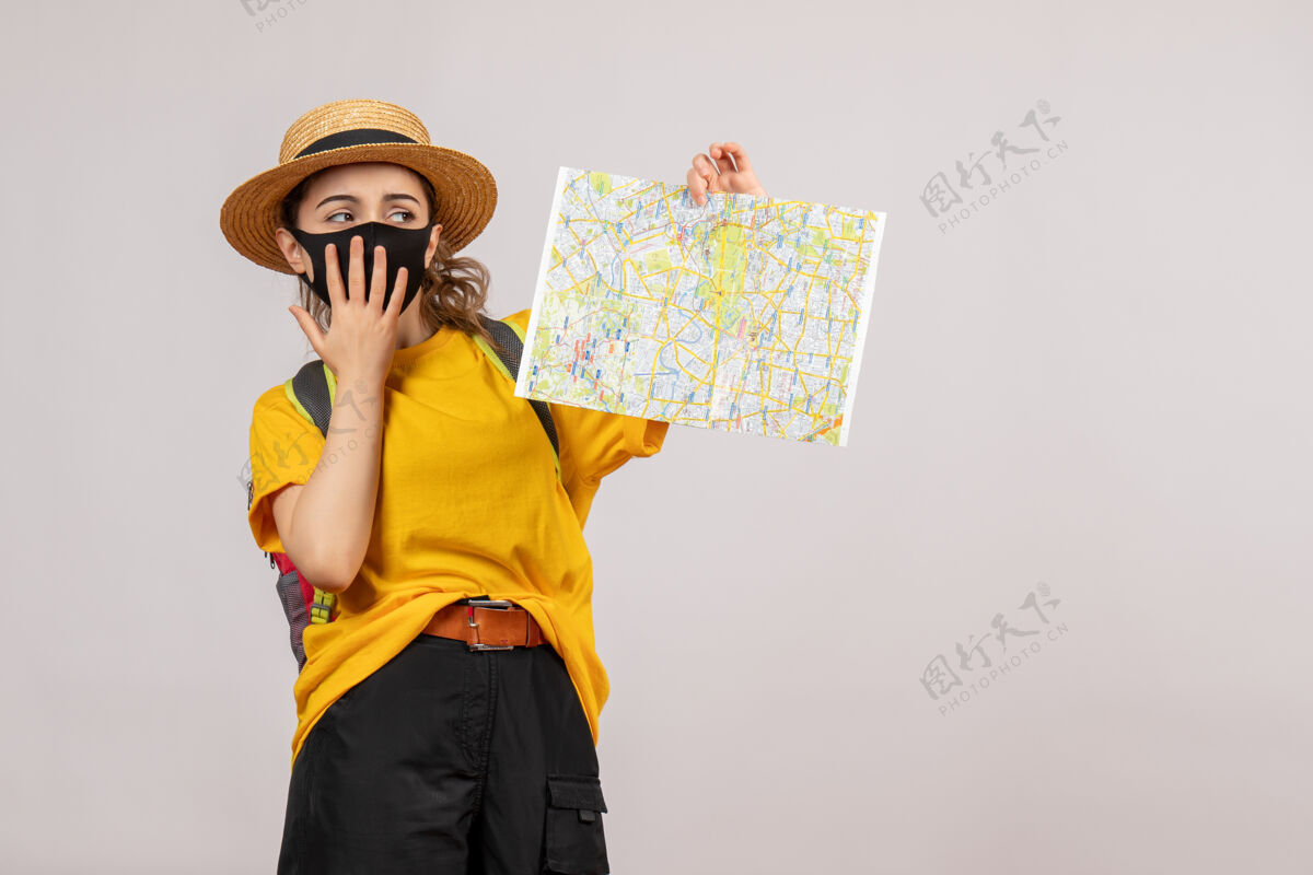 冒险前视图：背着背包的年轻女子举起地图 手放在嘴上面罩人灰色