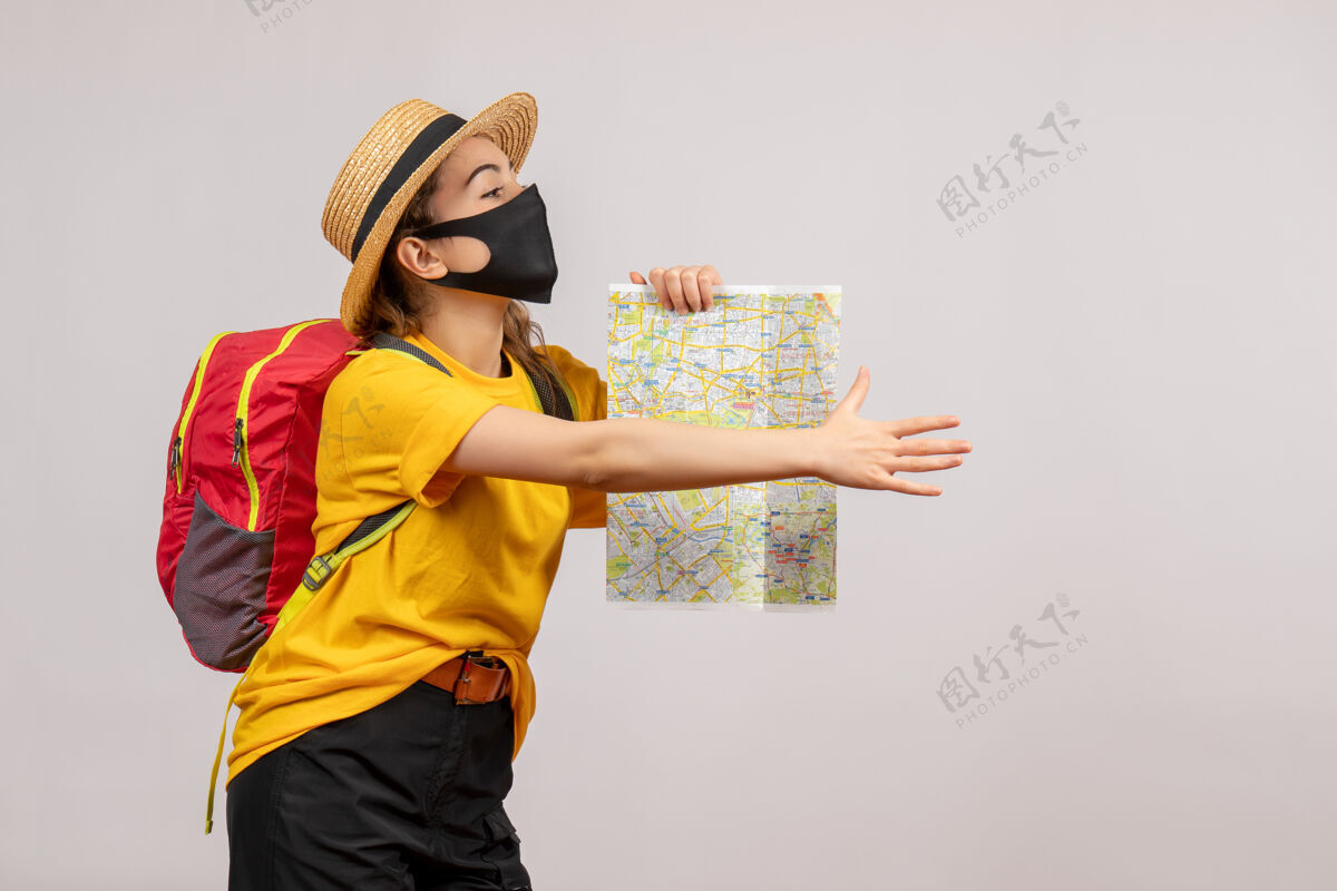 人正面图背着背包的年轻女子举着地图递着手度假持有手