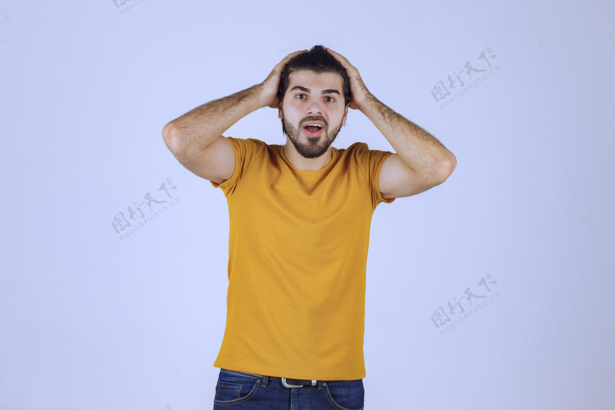 人类穿黄色衬衫的男人摆出诱人的姿势年轻人聪明休闲