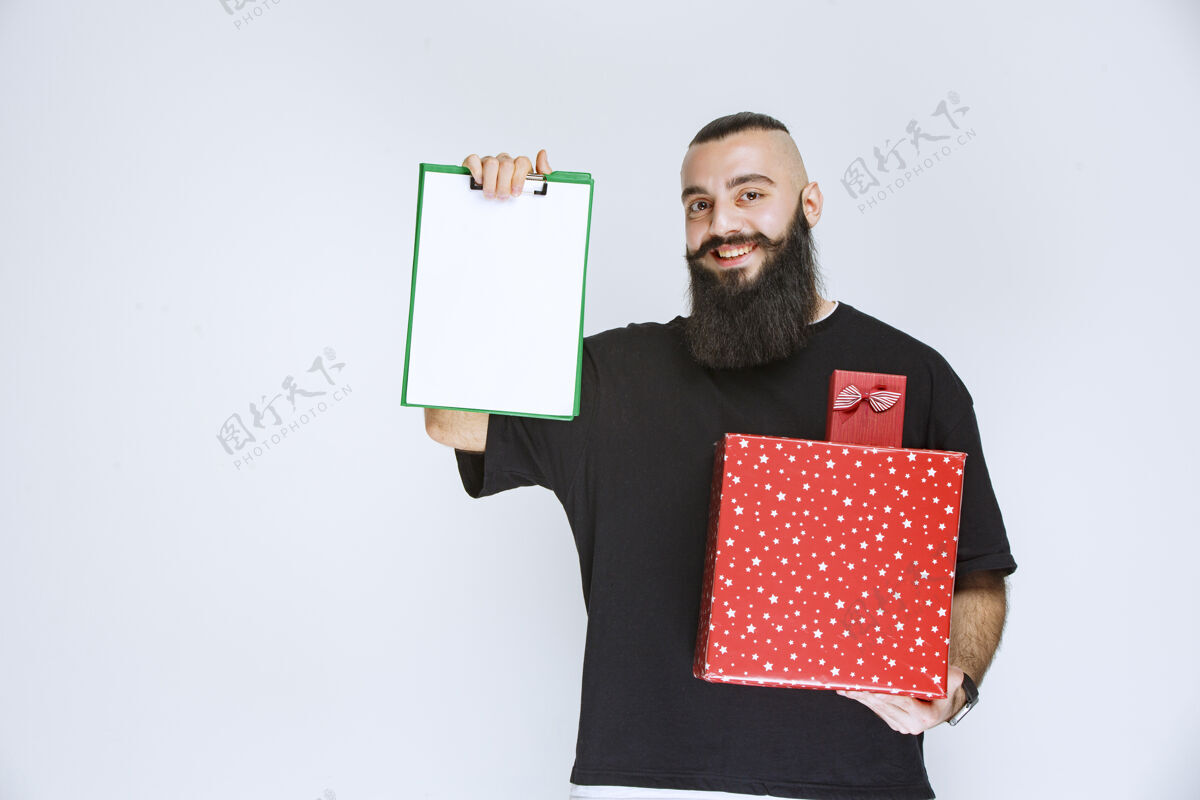 工人有胡子的男人拿着红色的礼盒 要求在送货单上签名男性休闲人