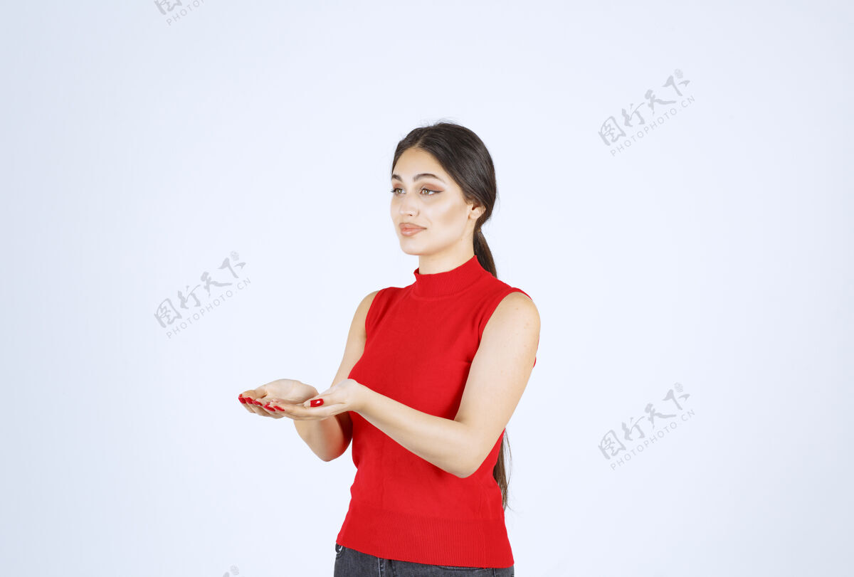 人穿红衬衫的女孩展示手里的东西成人女人服装