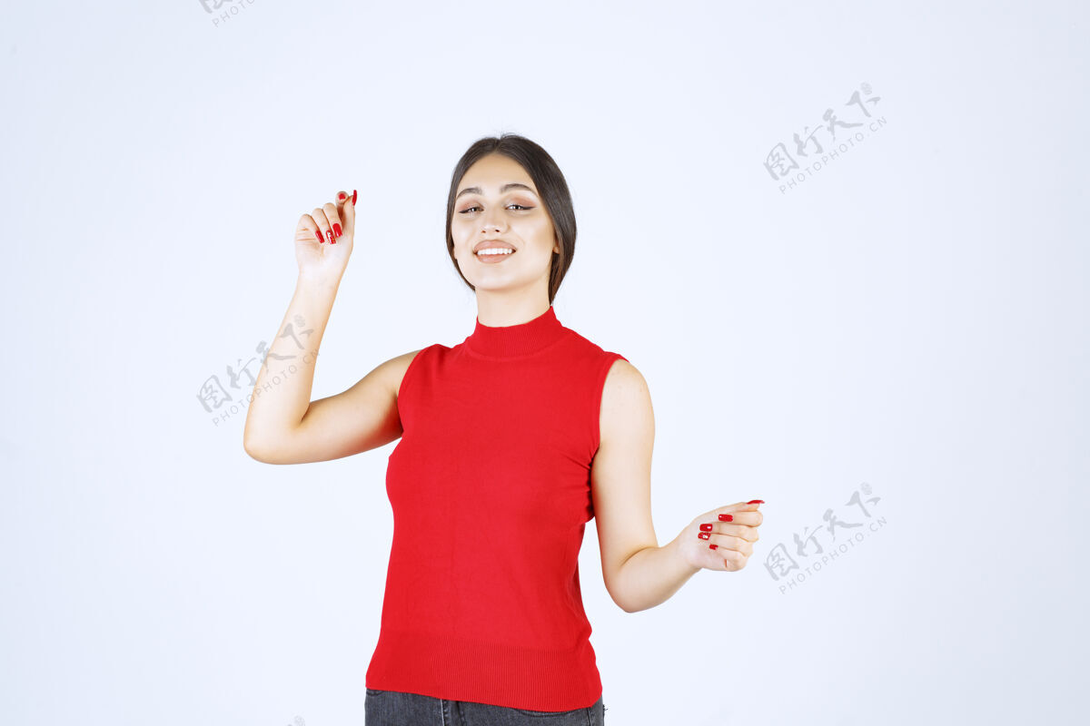 休闲穿红衬衫的女孩摆出中性 积极和吸引人的姿势人满意年轻