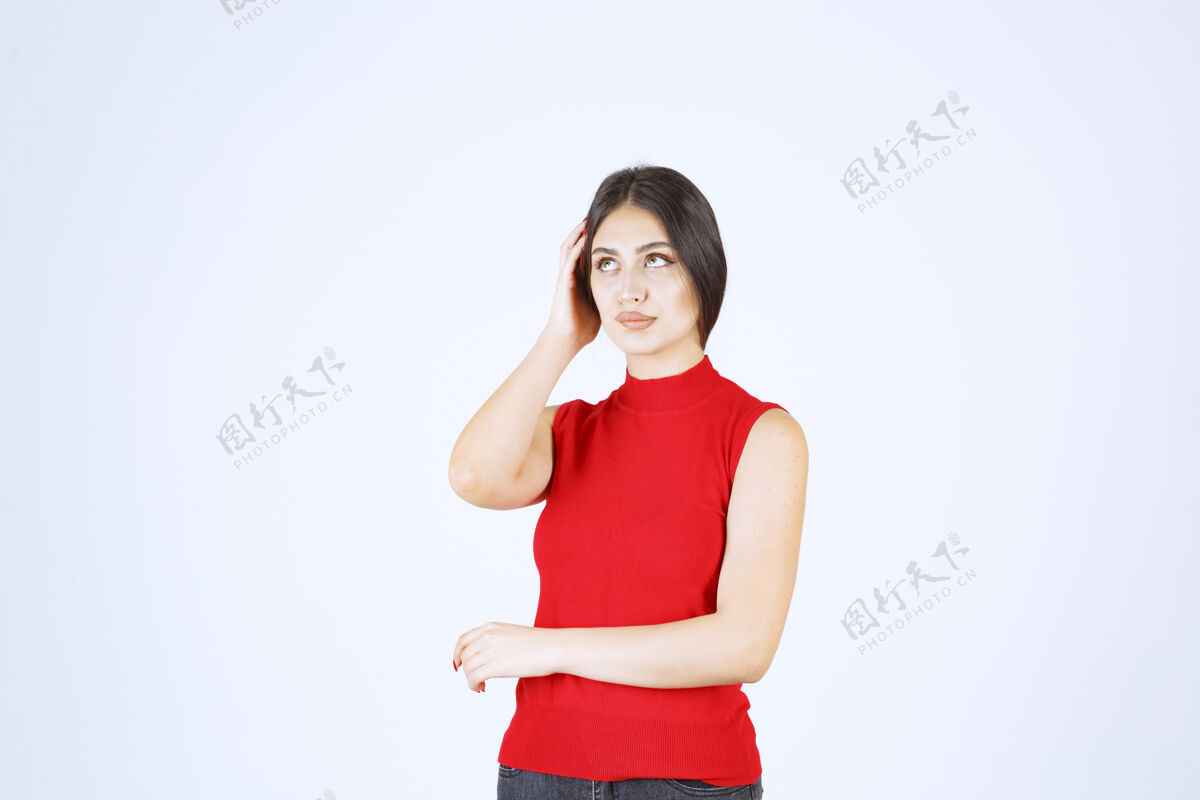 年轻穿红衬衫的女孩做着烦人无聊的脸人类打扮女人