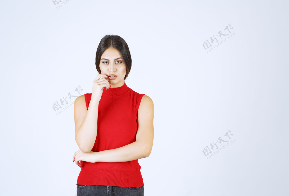 姿势穿红衬衫的女孩在思考和分析女人员工人