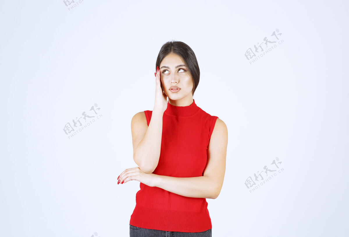 无聊穿红衬衫的女孩看起来既伤心又失望怀疑随意思想