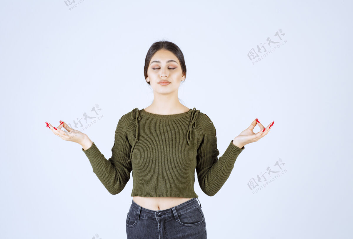 站立一个年轻放松的女模特站着冥想冥想人类女孩