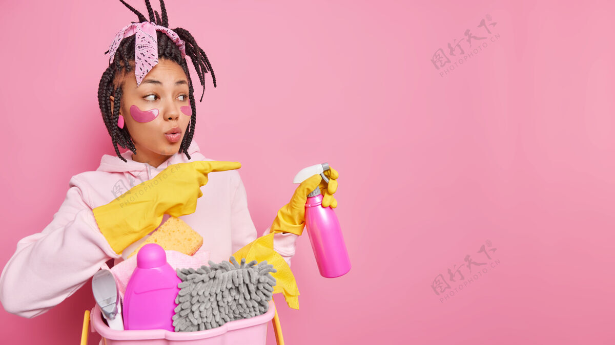 瓶子家庭主妇拿着喷雾清洁剂准备清洁服务 在复印空间旁注明给出想法或提示戴着橡胶手套休闲服隔离在粉色上家庭补丁洗