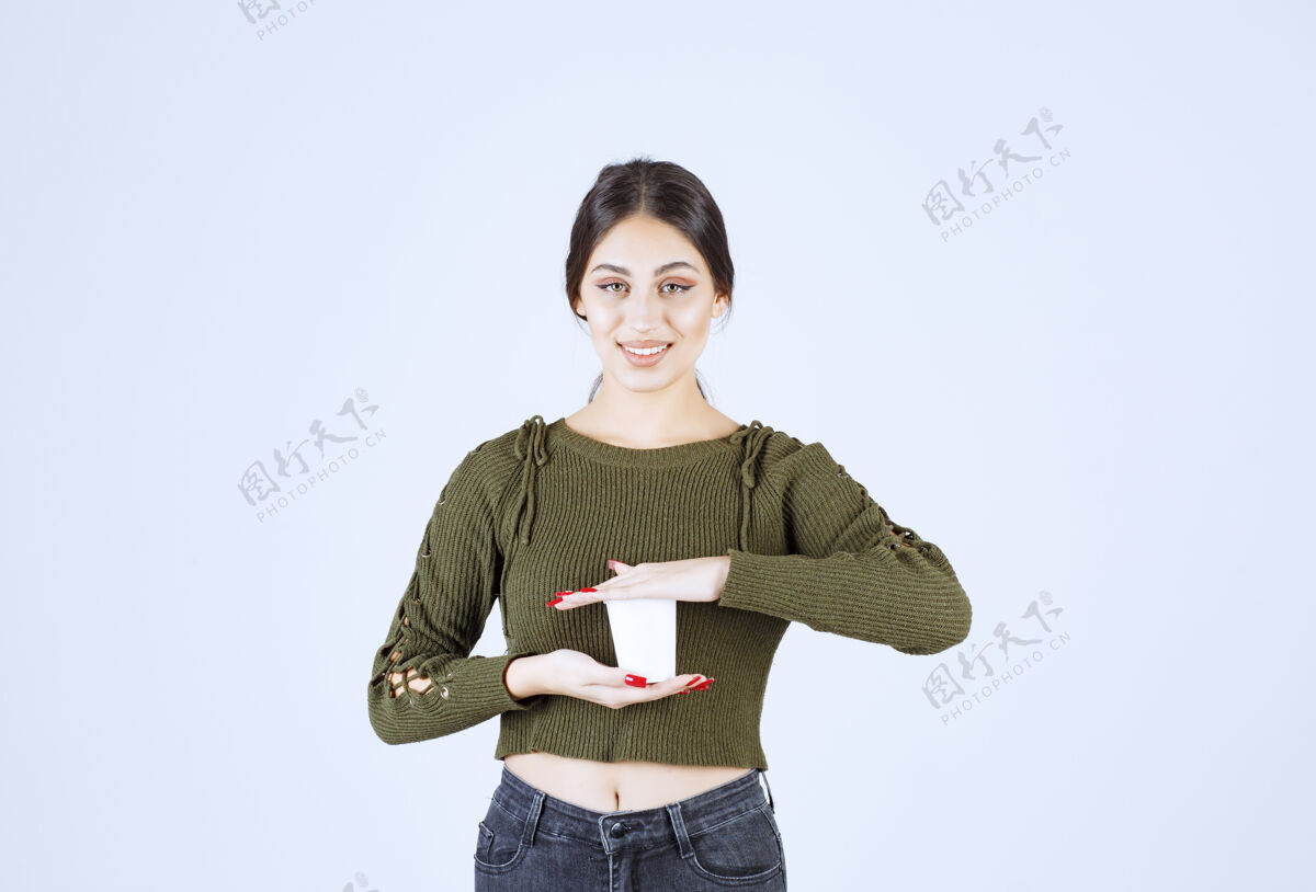 年轻年轻的黑发女人拿着塑料杯 开心地摆姿势持有人成人