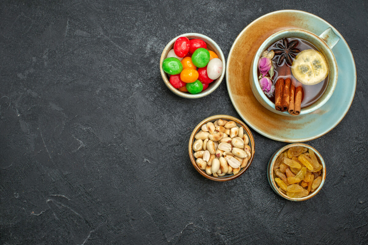 胡椒顶视图一杯茶与糖果和坚果的灰色空间碗餐厅晚餐