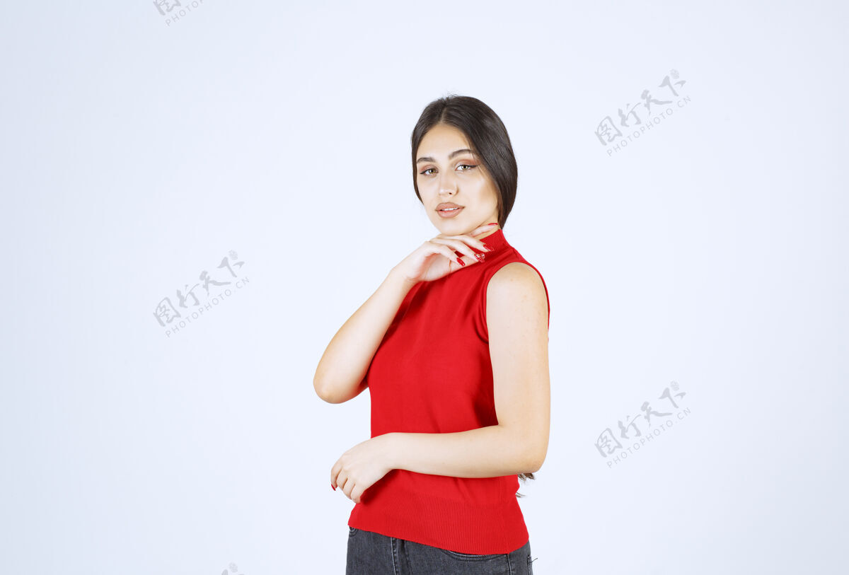 雇员穿红衬衫的女孩摆出可爱诱人的姿势成人女性年轻