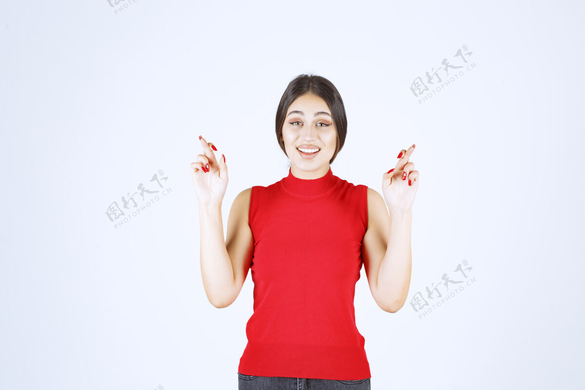 年轻人穿红衬衫的女孩显示手指交叉标志员工工人女人