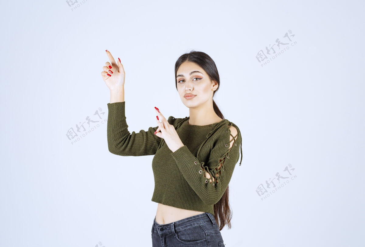 人类年轻微笑的女模特站在一边 用食指指着一边女士女人肖像