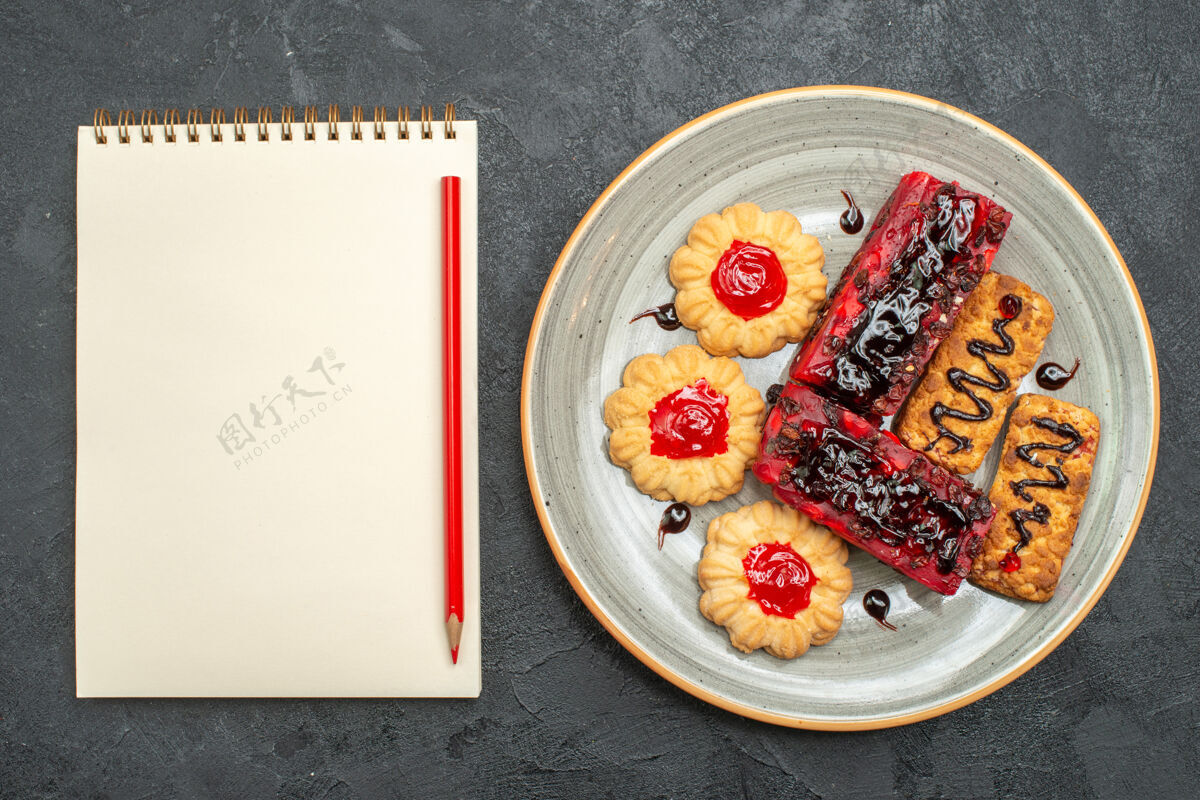饼干俯瞰美味的水果蛋糕和饼干在灰色的桌子饼干蛋糕饼干甜胡椒食物容器