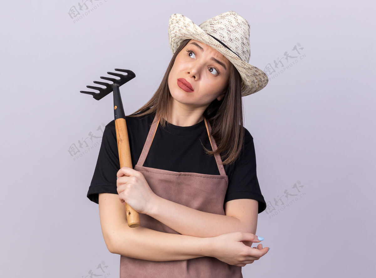 帽子焦急美丽的白人女园丁戴着园艺帽拿着耙子看着身边园艺女漂亮
