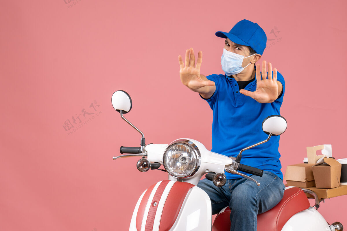 摩托车戴着医用面罩的快递员戴着帽子坐在滑板车上的俯视图 在柔和的桃色背景上显示十个车辆医疗快递员