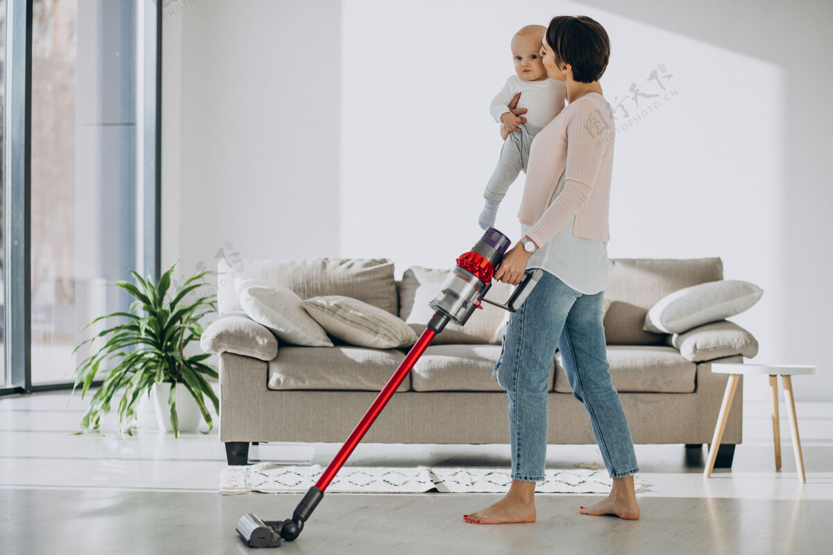 充电年轻妈妈带着蹒跚学步的儿子在家打扫卫生清洁灰尘家务