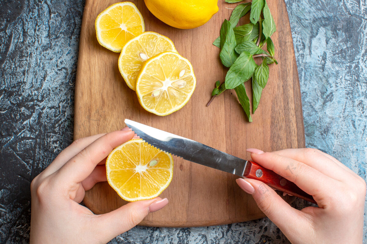 水果一个手切新鲜柠檬和薄荷木砧板上黑暗背景的特写镜头木材果汁葡萄柚