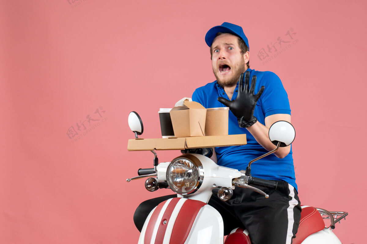 工作正面图身穿蓝色制服的男快递员手持咖啡和食品盒 骑着粉色服务快餐车工作高尔夫盒子快餐